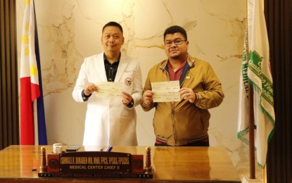 <p><strong>MEDICAL AID</strong>. Dr. Ismael Dimaren, chief of hospital of the Cotabato Regional and Medical Center (CRMC) (left), shows two of the four checks that Mohd Asnin Pendatun, BARMM cabinet secretary and head of “Ayudang Medikal mula sa Bangsamoro Government” (AMBaG) program, has turned over to CRMC for indigent patients on Wednesday (Aug. 14, 2024). The BARMM government donated more than PHP31 million to the CRMC for the medical needs of indigent patients in the region. <em>(Photo courtesy of CRMC)</em></p>