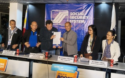 <p><strong>MOA SIGNING</strong>. Social Security System president and chief executive officer Rolando Macasaet and Baguio City Mayor Benjamin Magalong (3rd and 4th from left) show a copy of a signed memorandum of agreement in Baguio City on Tuesday (Aug. 20, 2024). The agreement authorizes the local government to collect SSS membership premiums of 525 job order and contract of service city hall workers. <em>(PNA photo by Liza T. Agoot)</em></p>