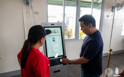 <p><strong>QR CODE</strong>. Camiguin Gov. Xavier Jesus Romualdo (right) tries the Quick Response (QR) registration system in the receiving kiosk as part of the island province's tourism campaign in March 2019. The QR registration is required to enter the island.<em> (File photo courtesy of DOT-10)</em></p>