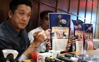 <p><strong>MALICIOUS, UNFOUNDED CLAIMS.</strong> Special Envoy to China Benito Techico on Monday (Aug. 26, 2024) shows the media copies of a photo earlier presented by lawyer Ferdinand Topacio to dismiss his insinuations that the First Couple had ties with some POGO personalities, based on a group photo taken in 2020. Benito, in a press conference held at a mall in Pasay City, called Topacio's claim "malicious and unfounded". <em>(PNA photo by Ben Pulta)</em></p>