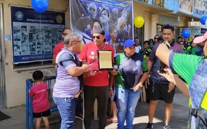 <p><strong>WARM WELCOME.</strong> Coach Allen Aldrin Castañeda receives a plaque from Hipodromo Barangay Captain Ruperto Bacolod shortly after the motorcade and homecoming activity for the trainer of two-time Olympic gold medalist Carlos Yulo, in front of the Barangay Hall on Monday (Aug. 26, 2024). Castañeda is also set to visit Acting Mayor Raymond Alvin Garcia on Tuesday (Aug. 27) at the Cebu City Hall. <em>(Contributed photo)</em></p>