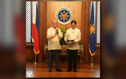 <p><strong>COMMEMORATIVE COINS</strong>. President Ferdinand R. Marcos Jr. receives the 7,500-Piso Gold and 750-Piso Silver commemorative coins from Bangko Sentral ng Pilipinas Governor Eli Remolona Jr. at Malacañang in Manila on Tuesday (Aug. 27, 2024). The designs highlight the diamond anniversary of central banking in the country. <em>(Photo from BSP)</em></p>