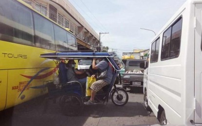 <p><strong>TRAFFIC JAM.</strong> A tricycle is caught in between bigger vehicles at a busy intersection in Dumaguete City, Negros Oriental province in this undated photo. The city government is targeting the completion of two new bridges in the outskirts of barangays by December 2024 to ease traffic woes. <em>(PNA file photo by Mary Judaline Flores Partlow)</em></p>
<p> </p>