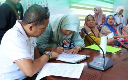 <p><strong>FOOD SUFFICIENCY</strong>. An officer of a farmers’ cooperative signs documents for the financial intervention during a loan assistance program extended to them by the Bangsamoro Autonomous Region in the Muslim Mindanao government in Cotabato City on Wednesday (Aug. 28, 2024). To ensure food sufficiency in the region, the Ministry of Agriculture, Fishery and Agrarian Reform (MAFAR) lends a PHP100,000 cash loan each to 23 farmer cooperatives in the area for more business engagements. <em>(Photo courtesy of MAFAR-BARMM)</em></p>