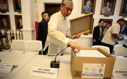 <p><strong>EVIDENCE.</strong> Justice Undersecretary Hermogenes Andres shows part of the evidence against former Bamban, Tarlac mayor Alice Guo that was presented before the Department of Justice on Friday (Aug. 30, 2024). Guo and 35 others were charged with 87 counts of money laundering involving PHP7 billion in assets of the “scam farm” operations in Central Luzon. <em>(PNA photo by Ben Pulta)</em></p>