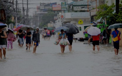 <p><strong>DANGER.</strong> Residents wade through flooded Bacoor, Cavite on Monday (Sept. 2, 2024). The Department of Health warns against rising cases of leptospirosis caused by contaminated water. <em>(PNA photo by Avito Dalan)</em></p>