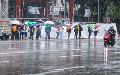 <p><strong>STORMY DAY.</strong> Commuters wait for their ride along Elliptical Road, Quezon City amid rains on Monday (Sept. 2, 2024). Classes and work in government offices were suspended Tuesday (Sept. 3, 2024) due to Tropical Storm Enteng. <em>(PNA photo by Robert Oswald P. Alfiler)</em></p>