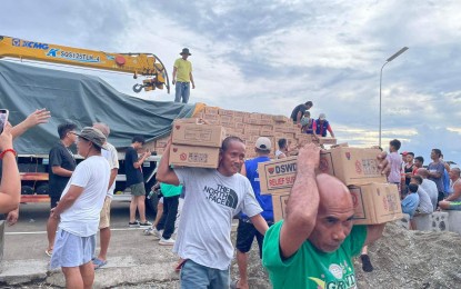 <p><strong>RELIEF DISTRIBUTION</strong>. Residents of Albay province affected by Tropical Storm Enteng receive family food packs from the Department of Social Welfare and Development in Bicol on Monday (Sept. 2, 2024). The agency has PHP210 million worth of stockpiles of relief supplies and standby funds, ready for deployment as necessary<em>. (Photo courtesy of DSWD Bicol)</em></p>