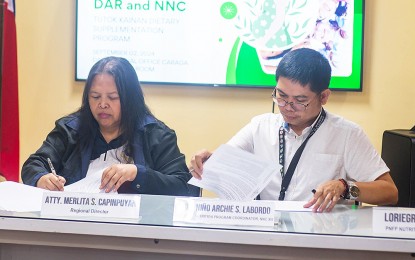 <p><strong>MOA FOR ARBOs</strong>. Department of Agrarian Reform (DAR) 13 (Caraga Region) Director Merlita Capinpuyan (left) and Dr. Niño Archie Labordo of the National Nutrition Council (NNC) 13 sign a memorandum of agreement in Butuan City on Monday (Sept. 2, 2024). The agreement will see two Agrarian Reform Beneficiaries Organizations from Surigao del Norte and Surigao del Sur supplying rice and other agricultural products for the NNC’s feeding program. <em>(Photo courtesy of DAR-13)</em></p>