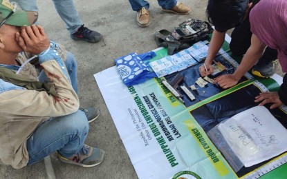 <p><strong>BUSTED.</strong> An arrested militiaman (seated) covers his face as a Philippine Drug Enforcement Agency (PDEA) agent accounts for the PHP3.4 million worth of 'shabu' following an entrapment operation in Tamparan, Lanao del Sur, on Tuesday (Sept. 3, 2024). The suspect, Alonto Pampa, has been tagged as a high-value target by the PDEA. <em>(Photo courtesy of PDEA-BARMM)</em></p>