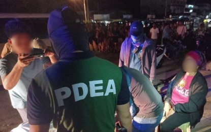 <p><strong>NO ROLE MODEL.</strong> Joint Philippine Drug Enforcement Agency and police officers arrest a female teacher (right, seated) following a buy-bust in Barangay Poblacion, Ipil, Zamboanga Sibugay, on Friday night (Sept. 6, 2024). Seized from the suspect were some PHP1.02 million worth of suspected shabu. <em>(Photo courtesy of PDEA-9)</em></p>