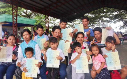 <p><strong>OFFICIALLY REGISTERED.</strong> Couple Julito Amper, 50, and wife Marisa Amorganda, 48, and their nine children show the birth certificates in official security paper they received for free through the Birth Registration Assistance Project of the Philippine Statistics Authority at the covered court of Barangay Carol-an, Kabankalan City, Negros Occidental on Sept. 4, 2024. The family set the record for having the most number of birth registrations filed at the same time under a single household in Negros Occidental and the country. (<em>Photo courtesy of Philippine Statistics Authority-Negros Occidental)</em></p>