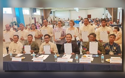 <p><strong>PEACEFUL AT LAST</strong>. Key officials from Biliran provincial government, military, and police hold a copy of the resolution declaring the province as completely free from the influence of armed rebels during a ceremony in Naval, Biliran on Wednesday (Sept. 11, 2024). Biliran is the first province in Eastern Visayas to earn the Stable Internal Peace and Security status. <em>(PNA photo by Roel Amazona) </em></p>