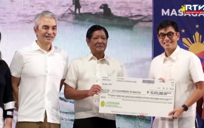 <p><strong>CASH AID.</strong> President Ferdinand R. Marcos Jr. leads the distribution of assistance to Navotas fisherfolk and families affected by the Bataan oil spill incident in a turnover ceremony at the Navotas Sports Complex on Thursday (Sept. 12, 2024). Marcos handed over the cheque to the Navotas city government.<em> (RTVM screengrab)</em></p>