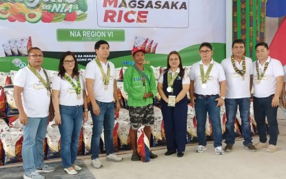 <p><strong>CHEAPER RICE.</strong> City resident Jolly Pama (fourth from left) buys a bag of 10 kilos of rice at PHP29 per kilo at the Kadiwa store during the grand launching of the Bagong Bayaning Magsasaka (BBM) rice at the NIA regional office in Iloio City on Friday (Sept. 13, 2024). The National Irrigation Administration prepared 1,000 bags at 10 kilos per bag for the vulnerable sector. <em>(PNA photo by PGLena)</em></p>