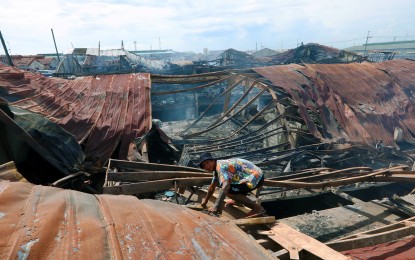 <p><strong>AFTERMATH.</strong> A resident returns to one of the collapsed structures in the razed Aroma Compound in Road 10, Barangay 105, Tondo, Manila on Sept. 15, 2024. The city government of Manila is appealing for donations for nearly 2,000 displaced families staying in three evacuation centers -- covered courts of Barangay 105 and 106 and General Vicente Lim Elementary School, and in modular tents along the center island of Mel Lopez Boulevard and Maginoo Street.<em> (PNA photo by Avito Dalan)</em></p>