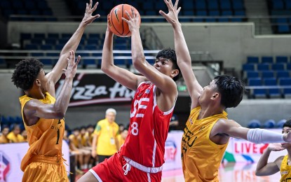 <p><strong>CROWDED LANE.</strong> UE's Gab Delos Reyes (No. 18) tries to score against two FEU defenders during the UAAP Season 87 high school basketball tournament at the Smart Araneta Coliseum on Wednesday (Sept. 18, 2024). The UE Red Warriors won, 82-74, to gain solo lead. <em>(UAAP photo)</em></p>