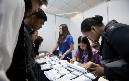 <p><strong>HOPEFULS.</strong> Jobseekers scour work offer flyers during the “Trabaho Turismo Asenso” job fair at SMX Convention Center in Pasay City on Thursday (Sept. 19, 2024). The job fair will have its final day on Saturday (Sept. 21). <em>(PNA photo by Yancy Lim)</em></p>