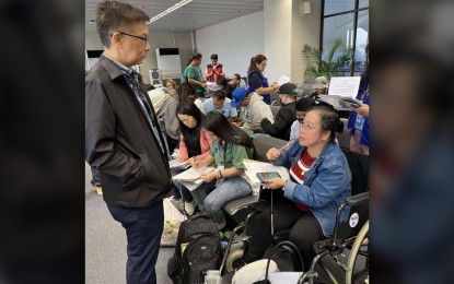 <p><strong>BACK HOME.</strong> Migrant Workers Secretary Hans Leo Cacdac speaks with an overseas Filipino worker at the Ninoy Aquino International Airport Terminal 1 in Parañaque City on Friday (Sept. 20, 2024). Forty-five Filipinos were brought back to after they availed of the amnesty program of the United Arab Emirates. <em>(Photo courtesy of DMW)</em></p>