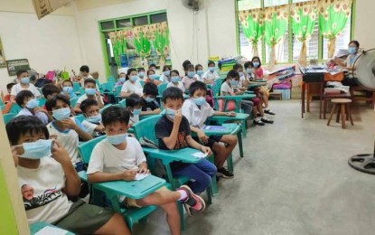 <p><strong>PROTECTION.</strong> A teacher and her pupils in a public elementary school in Moises Padilla, Negros Occidental, wear masks for protection from fumes coming from Mt. Kanlaon on Tuesday (Sept. 24, 2024). The sulfurous odor has been observed in the cities of Bago and La Carlota, as well as the municipalities of La Castellana and Pontevedra, according to the Provincial Disaster Risk Reduction and Management Office. <em>(Photo courtesy of Moises Padilla MDRRMO)</em></p>