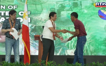 <p class="p1"><strong>DEBT CONDONATION</strong>. President Ferdinand R. Marcos Jr. leads the distribution of Certificates of Condonation and Release of Mortgage to 3,527 agrarian reform beneficiaries (ARBs) in a ceremony at the Eduardo Cojuangco Gymnasium in Paniqui, Tarlac on Monday (Sept. 30, 2024). The condonation of all unpaid principal amortizations, interest, and surcharges of ARBs on agricultural lands awarded under the agrarian reform program is mandated under Republic Act 11953 or the New Agrarian Emancipation Act (NAEA), which the President signed into law in July 2023. <em>(RTVM Screengrab)</em></p>