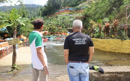 <p><strong>OCULAR INSPECTION</strong>. Provincial Environment and Natural Resources Office-Negros Occidental head Joan Nathaniel Gerangaya (right) inspects the resort where rocks and boulders have been painted with bright colors, considered vandalism, in late September. “Painting on natural rocks could potentially threaten the water quality of the river,” he said in a statement on Tuesday (Oct.1, 2024). <em>(Photo courtesy of PENRO Negros Occidental)</em></p>