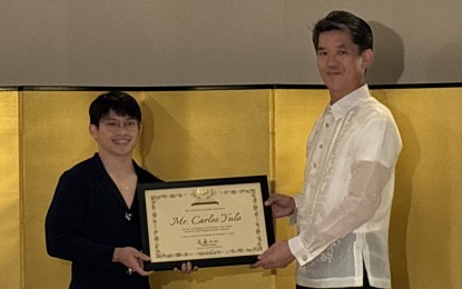 <p><strong>AMBASSADOR’S AWARD.</strong> Filipino Olympic double-gold winner Carlos Yulo (left) receives the Ambassador's Award from Japanese Ambassador to the Philippines Endo Kazuya at his residence in Makati on Tuesday night (Oct. 1, 2024). Kazuya cited how Yulo’s training in Japan made a significant contribution in honing his skills in gymnastics. (<em><strong>Photo by Joyce Rocamora)</strong></em></p>