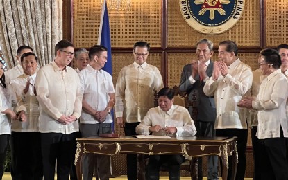 <p><strong>NEW LAW.</strong> President Ferdinand R. Marcos Jr. signs the Value Added Tax (VAT) on Digital Services Law at Malacañan Palace on Wednesday (Oct. 2, 2024). To be known as Republic Act 12023, the new law imposes a 12 percent VAT on foreign digital service providers, such as Netflix, Disney, and HBO, to generate additional revenue for the government and level the playing field for local providers. <em>(PNA photo by Darryl John Esguerra)</em></p>