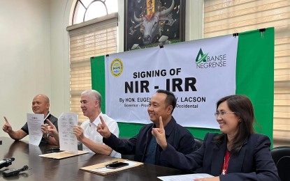 <p><strong>SIGNED.</strong> Negros Occidental Governor Eugenio Jose Lacson (2nd from left), with Provincial Administrator Rayfrando Diaz II (left), shows his signature on the implementing rules and regulations of the Negros Island Region (NIR) Act at the Provincial Capitol in Bacolod City on Wednesday (Oct. 2, 2024).  Department of the Interior and Local Government Director Dennis Villaseñor (3rd from left) and NIR OIC-Assistant Regional Director Teodora Sumagaysay witnessed the document signing. <em>(Photo courtesy of DILG-Negros Occidental</em>)</p>