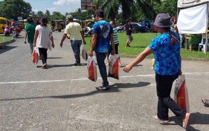 <p><strong>AFFORDABLE RICE.</strong> Vulnerable residents of Carmen town, Davao del Norte, carry 10-kilo bags of rice purchased at PHP29 per kilo during the Kadiwa ng Pangulo event held at the National Irrigation Administration (NIA) – Davao del Norte Irrigation Management Office on Friday (Oct. 4, 2024). Around 1,400 individuals benefited from the program. <em>(PNA photo by Robinson Niñal)</em></p>