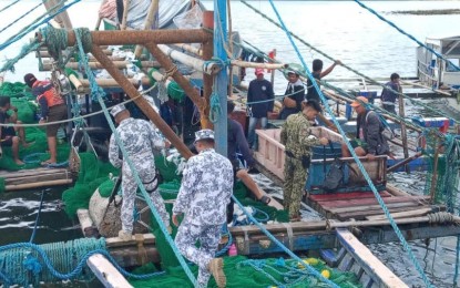 <p><strong>NABBED.</strong> A joint law enforcement team boards a fishing boat suspected of illegal fishing during a seaborne patrol in waters off Balesin Island in Polillo, Quezon on Sunday (Oct. 6, 2024). The Philippine Coast Guard on Tuesday (Oct. 8) said the 17 fishers were apprehended for having used the illegal 'Buli-Buli' fishing method. (<em>Photo courtesy of PCG)</em></p>