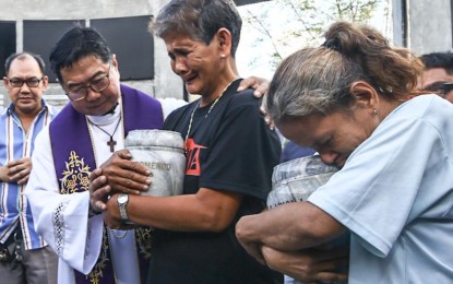 <p><strong>GRIEF</strong>. Relatives hold on tightly to the urns of their loved ones, who were alleged victims of extrajudicial killings during the Duterte administration, at the inurnment at the Dambana ng Paghilom (Shrine of Healing) inside La Loma Cemetery in Caloocan City on Wednesday (March 12, 2025). The shrine is for the casualties of the illegal drugs war. <em>(PNA photo by Joan Bondoc)</em></p>